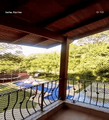 Varanda de sítio com rede de proteção e vista para piscina 